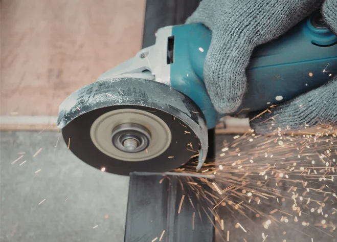 Sparks flying as an angle grinder cuts metal.